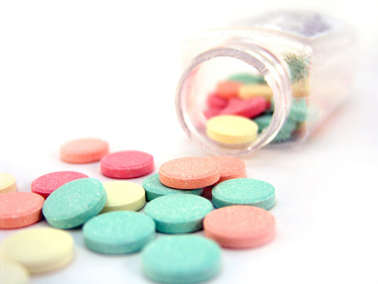 Free Colorful Antacid Tablets Pouring from Bottle Stock Photography