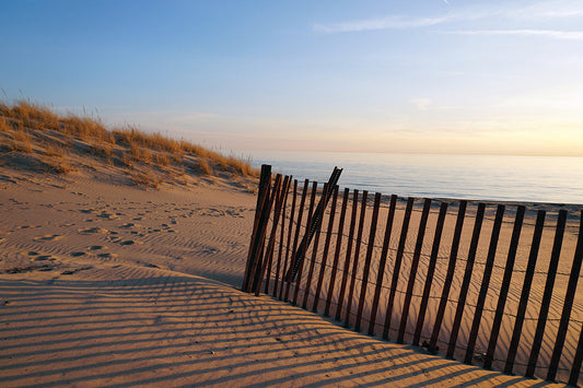 Free Sunset Over Sandy Dunes and Beach Fence Stock Photography