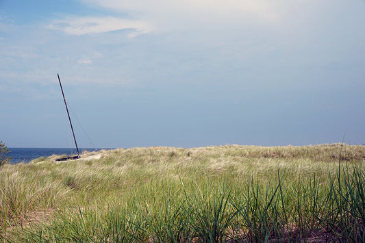 Free Grassy Dunes with Sailboat and Ocean View Stock Photography