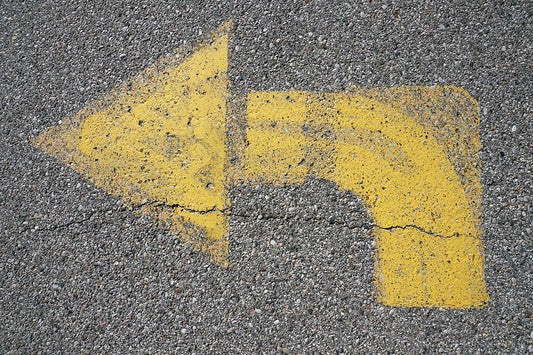 Free Curved Yellow Arrow on Pavement Stock Photography