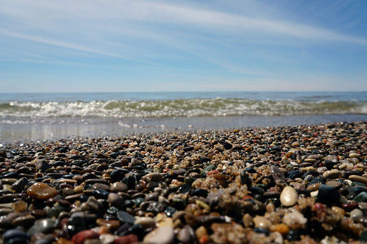 Free Lake Shore Pebbles and Rolling Wave Stock Photography