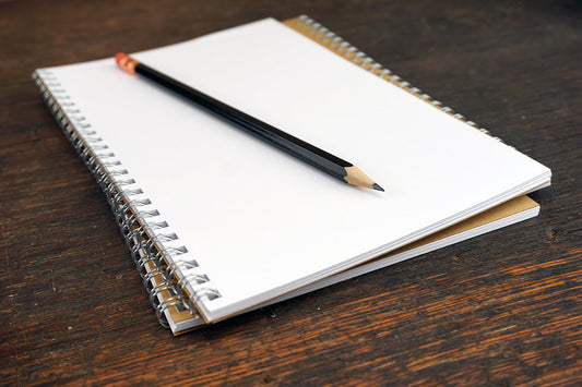 Free Black Pencil on Open Spiral Notebook Stock Photography
