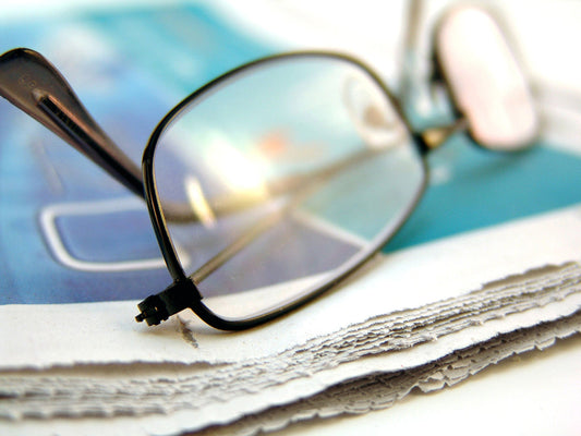 Free Eyeglasses on Torn Newspaper Edge Stock Photography