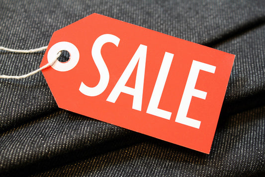 Free Red Sale Tag on Dark Fabric Stock Photography